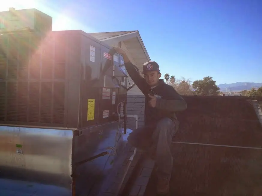 HVAC technician performing Air Duct Cleaning on a rooftop unit in Allamuchy