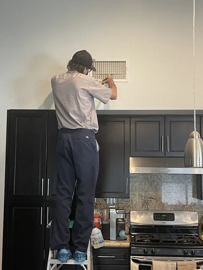 Technician inspecting an air vent during HVAC service in Allamuchy